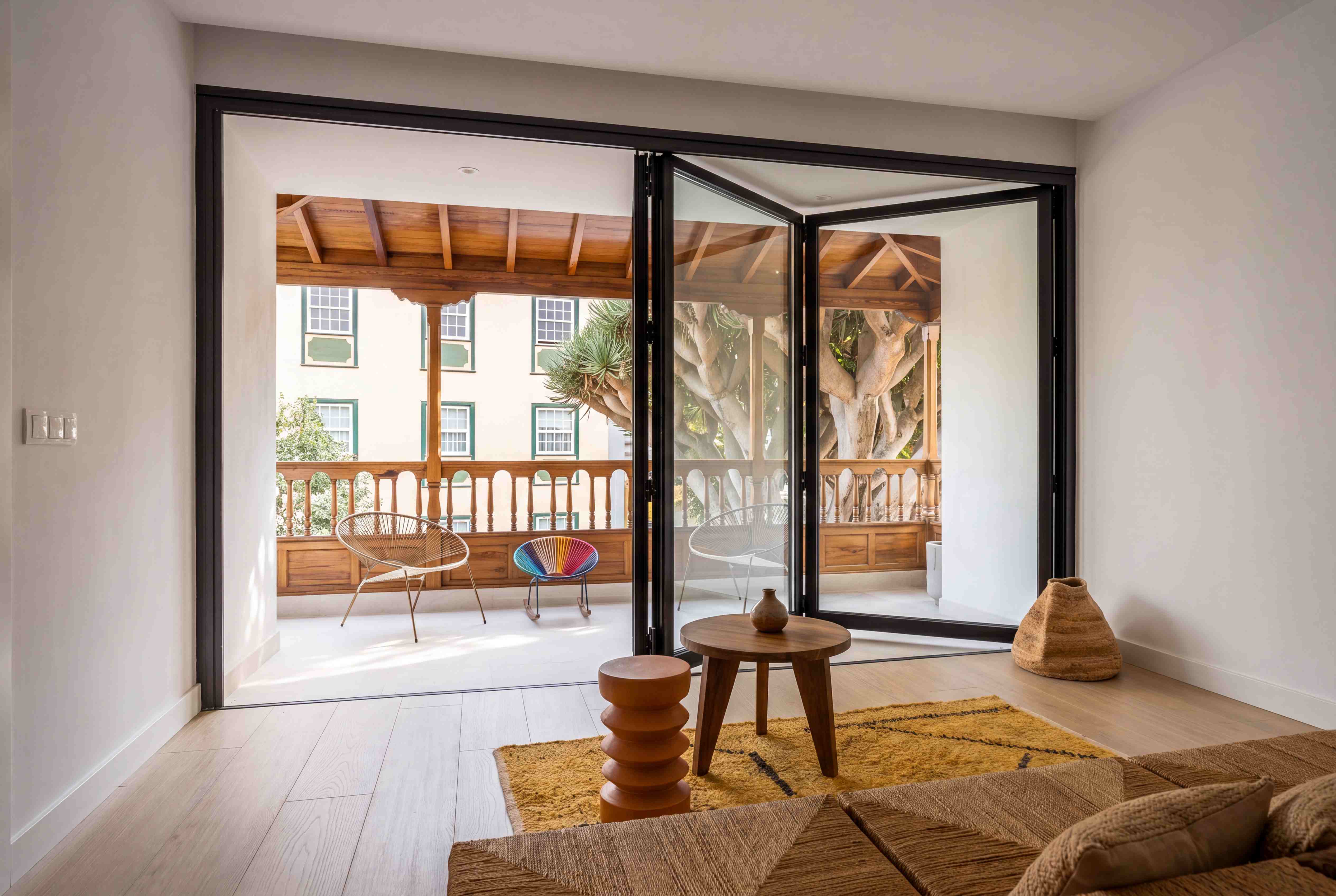 Black aluminium bi-fold doors opening a living space onto a terrace, typical of a Westminster project